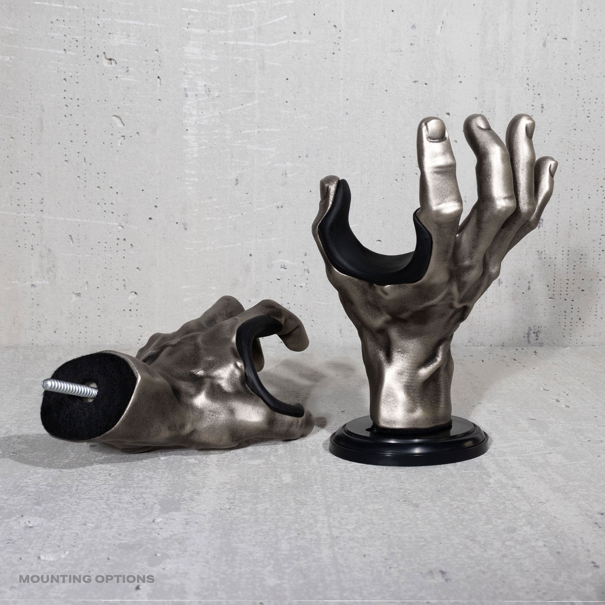 GuitarGrip metallic hand-shaped guitar wall mounts on a concrete surface.
