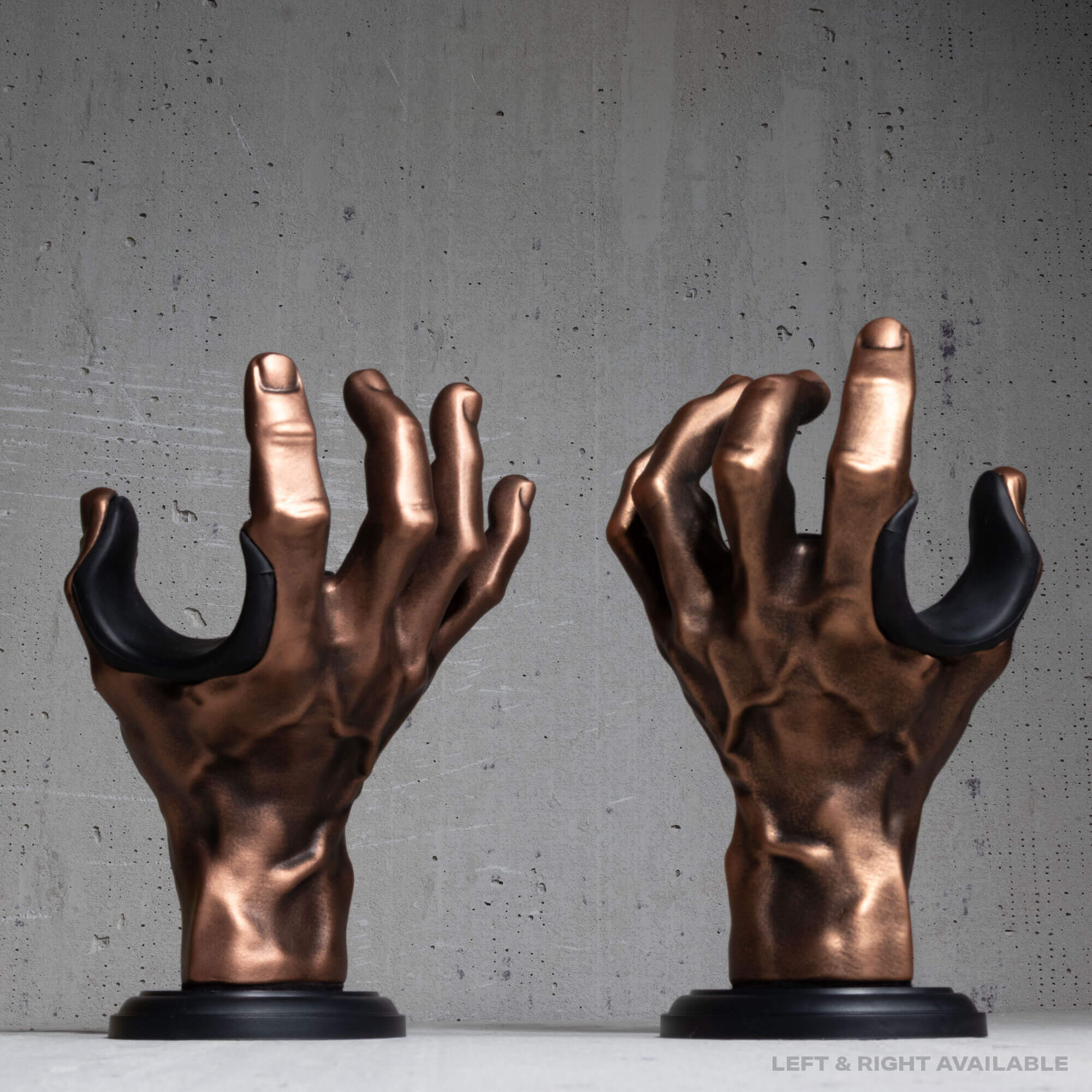 Pair of copper hand guitar hangers on grey wall.