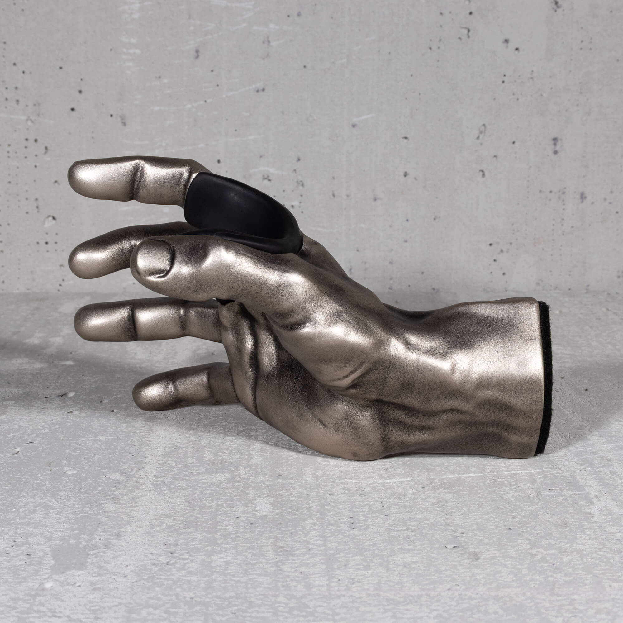 Inside view of antiqued silver hand used to mount instruments, specifically guitars, to the wall. 