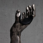 Silver hand guitar hanger wall mount sculpture against a gray background.

