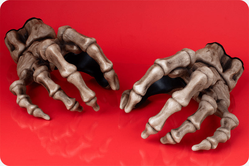 GuitarGrip skeleton hand electric guitar wall hooks on red background. 