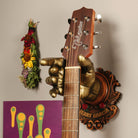 Jerry Garcia Officially Licensed Guitar Hanger from GuitarGrip. On wall with purple artwork and sage. 