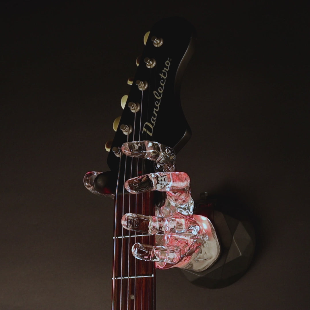 LED hand guitar hanger that glows in the dark. On black background.